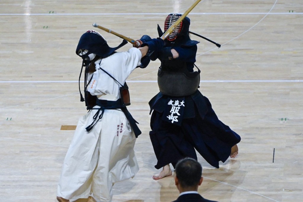 体育館の床に整列して正座する武蔵大学剣道部の部員たち。